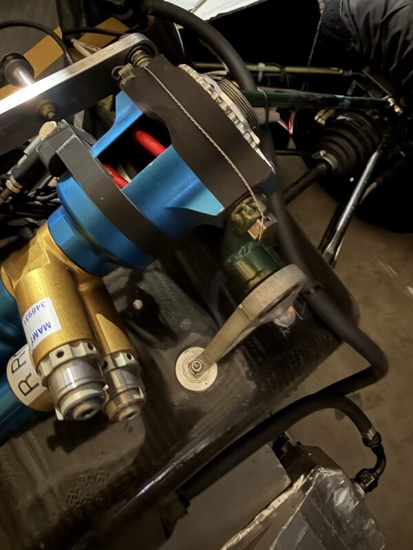 The roll damper, labelled R ROLL, on the shared bellcrank with the rocker arm and pushrod pickups around it.